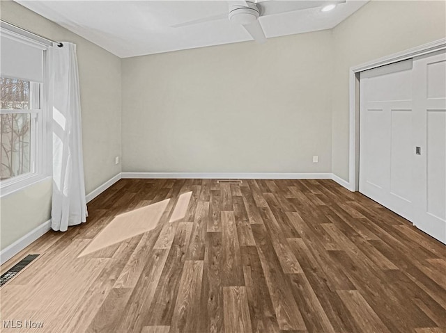 unfurnished bedroom featuring visible vents, wood finished floors, and baseboards