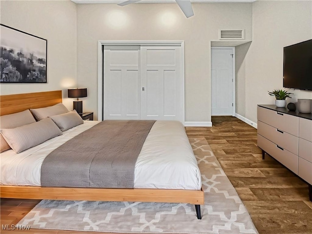 bedroom featuring visible vents, baseboards, a closet, and wood finished floors