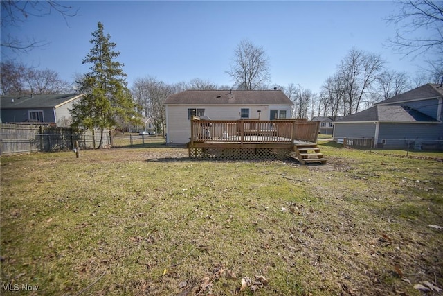 back of house featuring a lawn, a fenced backyard, and a wooden deck