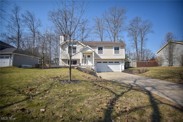 bi-level home with driveway, fence, a front yard, an attached garage, and a chimney