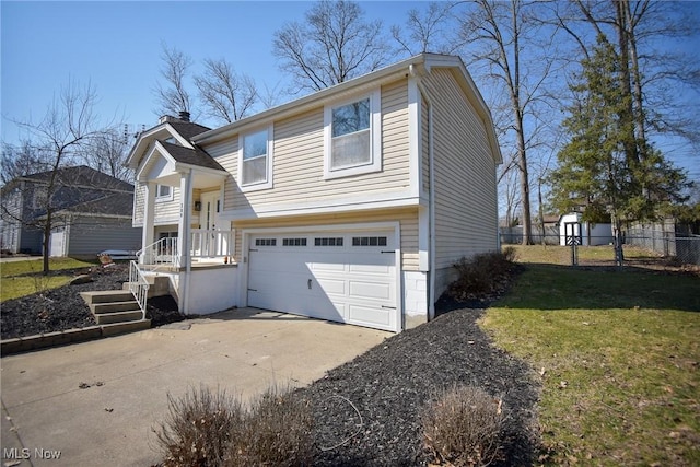 bi-level home featuring fence, an attached garage, a chimney, concrete driveway, and a front lawn