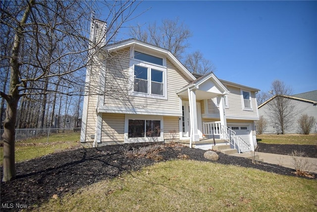 bi-level home featuring a front lawn, fence, concrete driveway, a chimney, and a garage