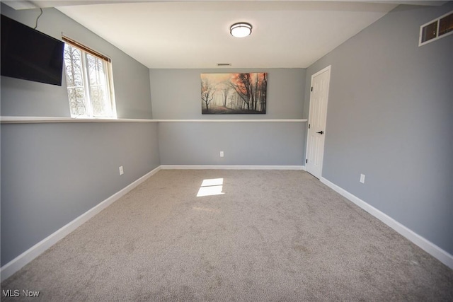 carpeted spare room featuring baseboards and visible vents