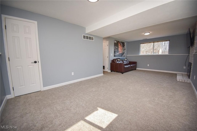 unfurnished bedroom with a brick fireplace, baseboards, carpet floors, and visible vents