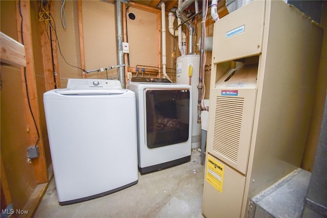 washroom featuring gas water heater, heating unit, separate washer and dryer, and laundry area