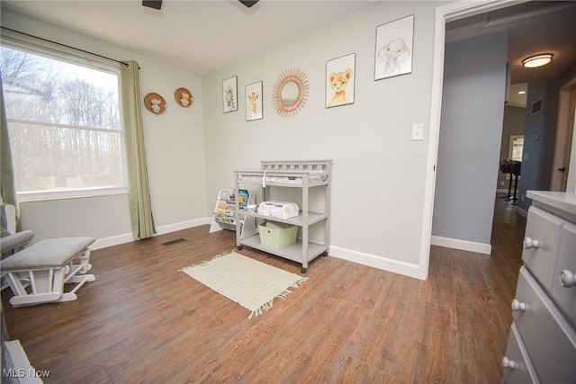 recreation room featuring visible vents, baseboards, and wood finished floors