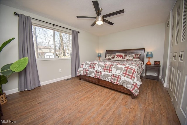 bedroom featuring a closet, a ceiling fan, baseboards, and wood finished floors