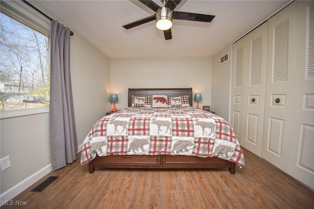 bedroom featuring visible vents, a closet, wood finished floors, and a ceiling fan