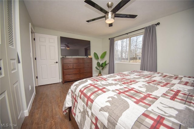 bedroom featuring baseboards, ceiling fan, and dark wood-style flooring