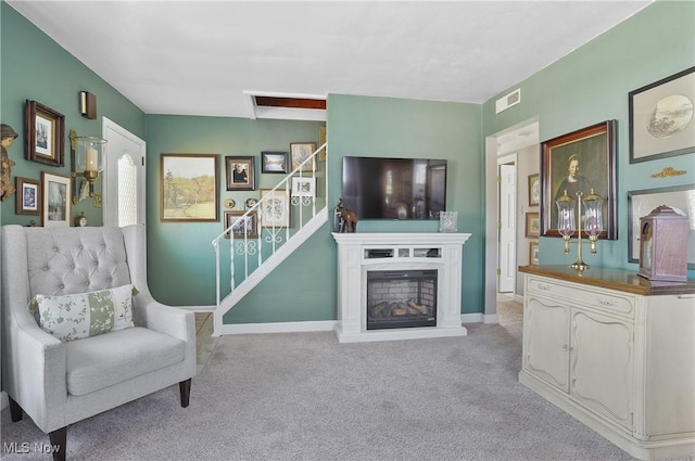 living area with visible vents, stairway, carpet floors, a fireplace, and baseboards