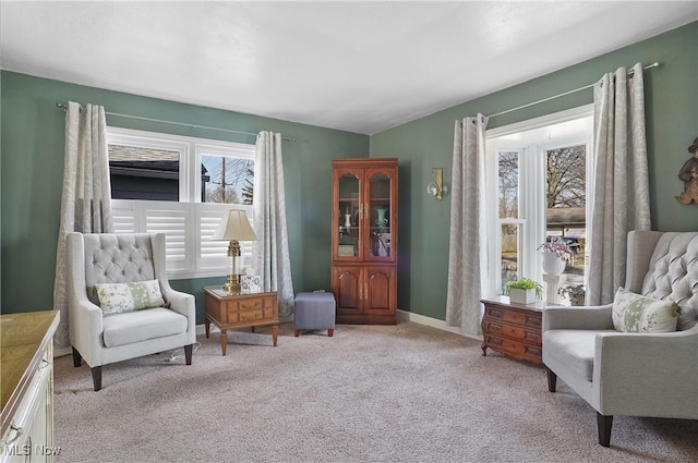 living area with light colored carpet and baseboards