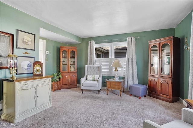 sitting room featuring baseboards and carpet