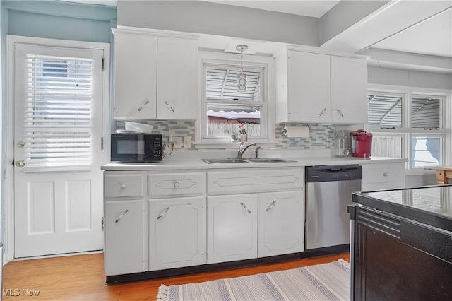 kitchen with a sink, white cabinets, black microwave, dishwasher, and light wood-type flooring