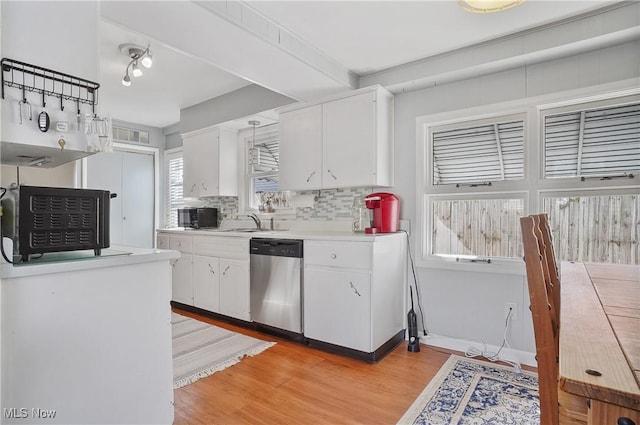 kitchen with white cabinetry, light wood finished floors, light countertops, dishwasher, and tasteful backsplash