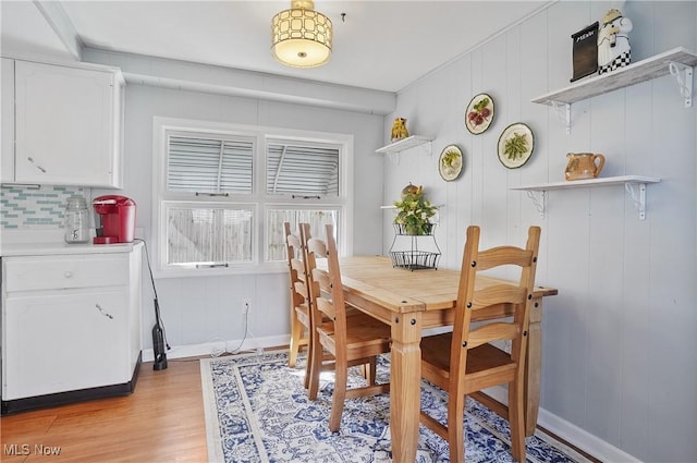 dining area with baseboards and light wood finished floors