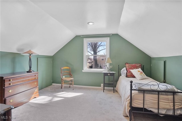 carpeted bedroom featuring baseboards and lofted ceiling