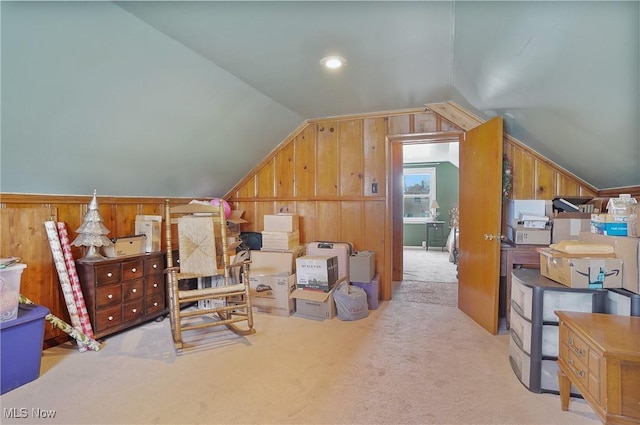 interior space with lofted ceiling, wood walls, and carpet floors