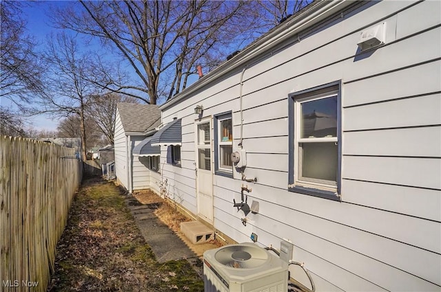 view of home's exterior with fence and central AC