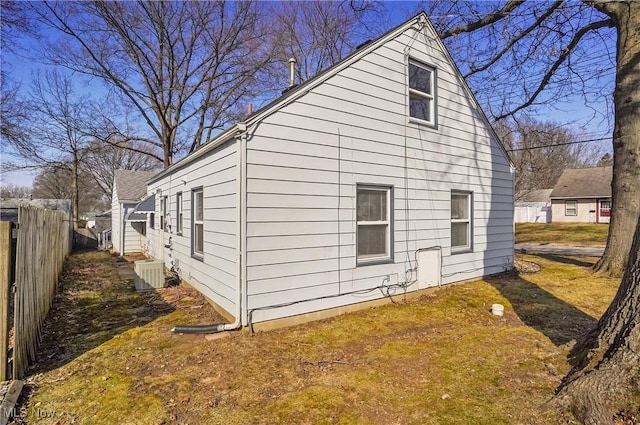 view of side of home featuring cooling unit and fence