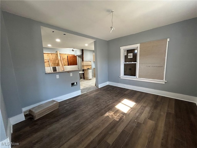 unfurnished living room with baseboards and wood finished floors