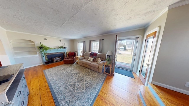 living area with built in features, a fireplace with flush hearth, light wood finished floors, and a textured ceiling