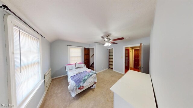 bedroom featuring baseboards, light carpet, ceiling fan, and vaulted ceiling