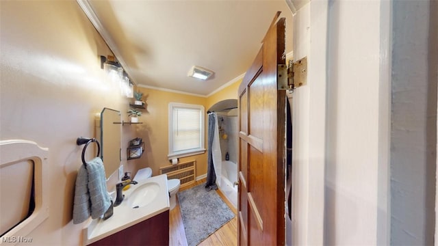 full bathroom featuring crown molding, radiator heating unit, wood finished floors, shower / bath combination with curtain, and vanity