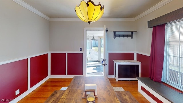 unfurnished dining area with ornamental molding and wood finished floors