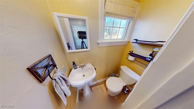 bathroom with baseboards and toilet