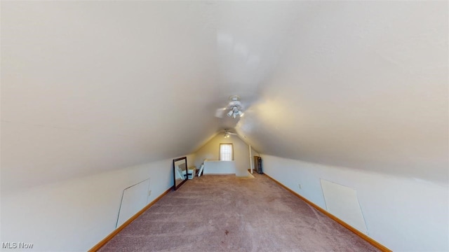 additional living space featuring baseboards, carpet, and vaulted ceiling