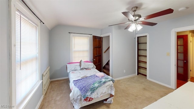 bedroom with baseboards, light colored carpet, a ceiling fan, and vaulted ceiling