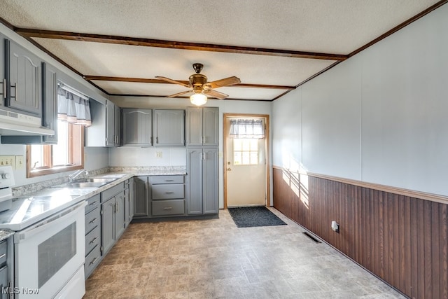 kitchen featuring under cabinet range hood, light countertops, gray cabinets, white electric range oven, and a sink