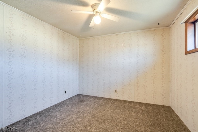 carpeted spare room with a textured ceiling, ceiling fan, and wallpapered walls