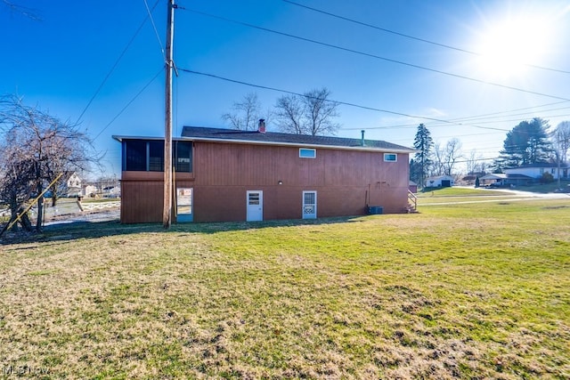 rear view of house featuring a lawn