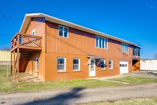 view of side of property featuring a garage, concrete block siding, and stairs