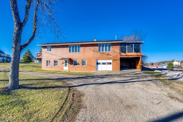 view of front of house featuring a sunroom, a front lawn, and dirt driveway