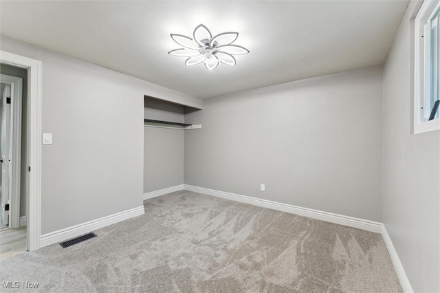 unfurnished bedroom featuring a closet, carpet flooring, baseboards, and visible vents