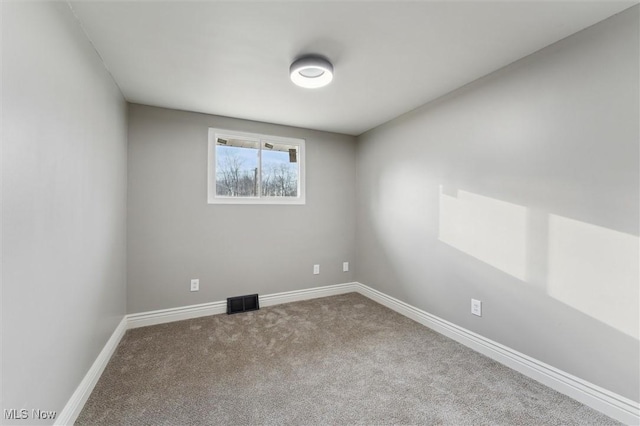 carpeted empty room featuring visible vents and baseboards