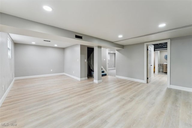 below grade area with stairs, recessed lighting, light wood-type flooring, and baseboards