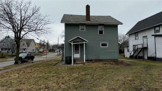 rear view of property with entry steps, a residential view, and a chimney