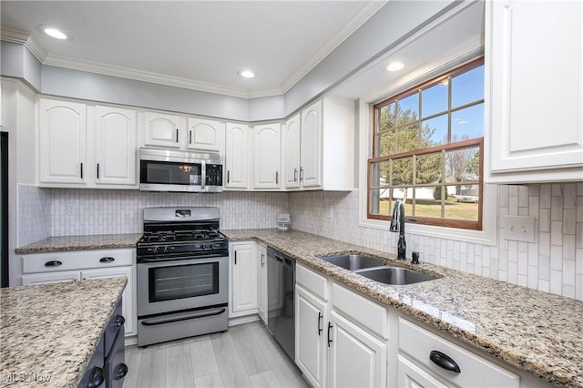 kitchen with white cabinetry, crown molding, appliances with stainless steel finishes, and a sink