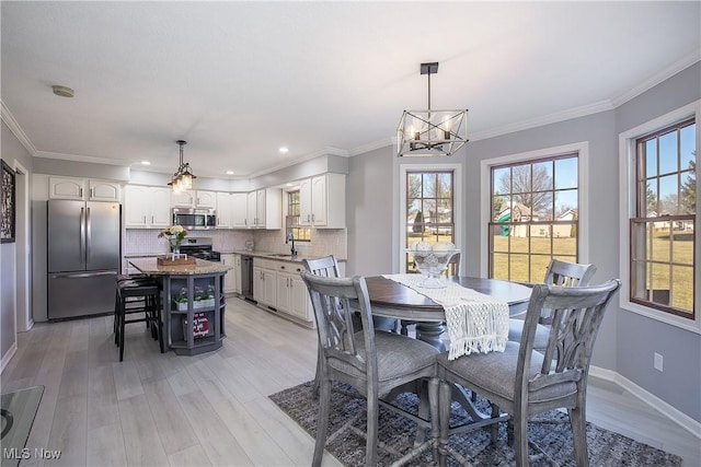 dining area with light wood-style floors and ornamental molding