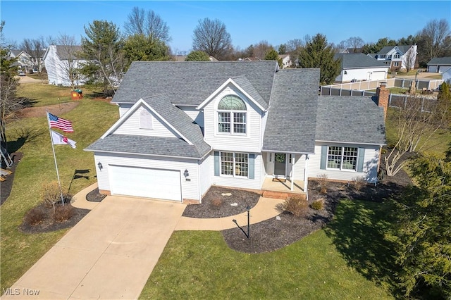 traditional-style home featuring concrete driveway, a front lawn, a garage, and roof with shingles