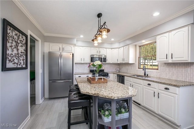 kitchen with white cabinets, light stone countertops, appliances with stainless steel finishes, and a sink