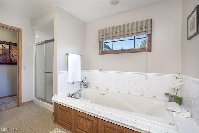 full bath with tile patterned floors, a garden tub, and a shower stall