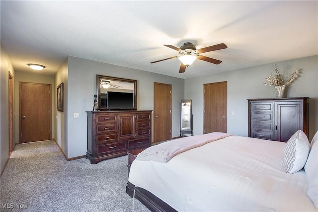 bedroom featuring a ceiling fan, light colored carpet, and baseboards