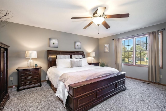 carpeted bedroom with visible vents, baseboards, and a ceiling fan