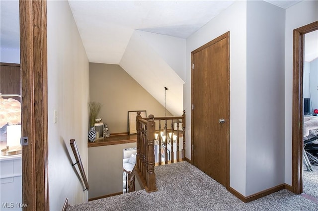 hall featuring baseboards, an upstairs landing, and carpet