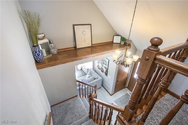 staircase featuring a chandelier, visible vents, baseboards, and vaulted ceiling