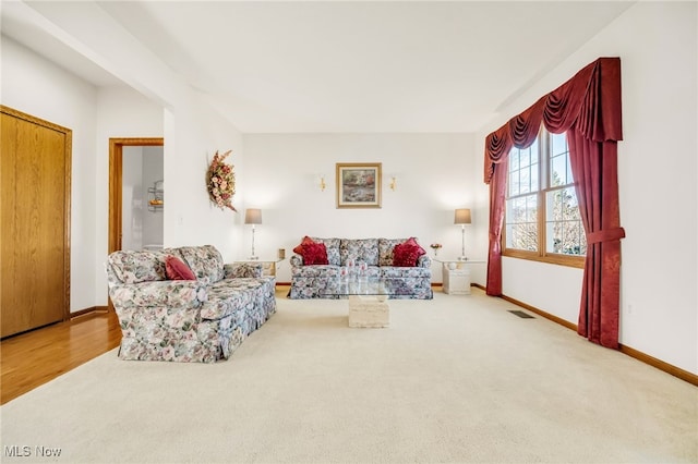 living room with visible vents, baseboards, and carpet floors